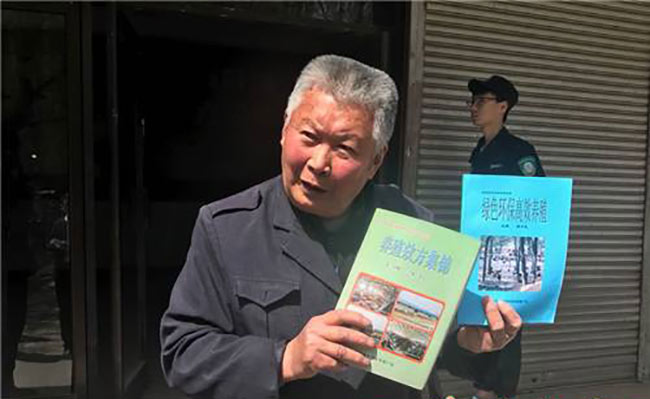 任民昌向记者展示自己参与编写的有关养殖方面的农业科技图书。