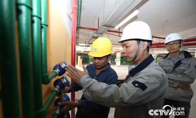 梁跃辉向工友讲解水表安装规范标准