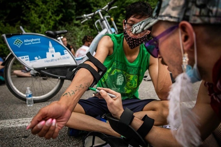 为防止意外 美国抗议者纷纷在手臂上写下紧急联系人电话