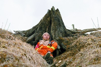 在四川凉山木里火场,森林消防员黄帅靠着树根短暂休息,这是他在火场