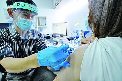 新加坡一家私立诊所的医生为一名女子注射科兴疫苗